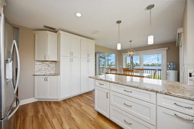 a kitchen with granite countertop white cabinets and white appliances