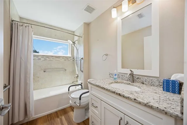 a bathroom with a granite countertop sink mirror vanity and bathtub