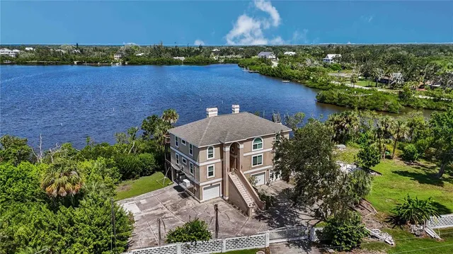 an aerial view of a houses with a yard and lake view