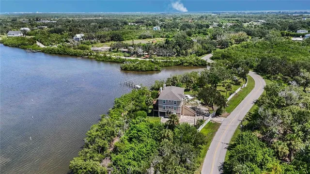 an aerial view of a houses with a yard and lake view