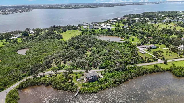 an aerial view of a house with a yard and lake view
