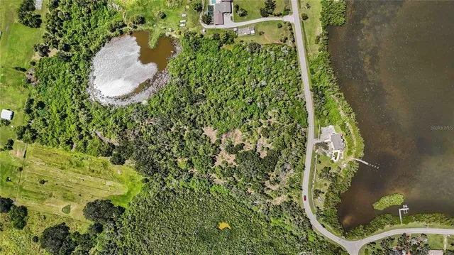 an aerial view of a house with a yard and lake view