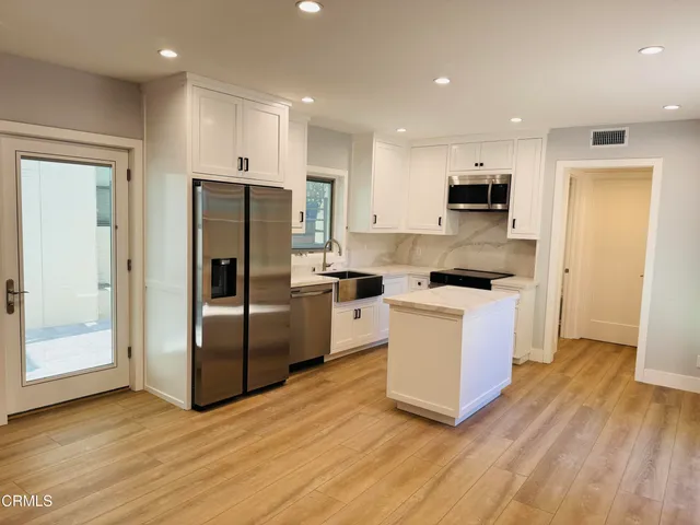 a kitchen with stainless steel appliances a refrigerator and a stove top oven