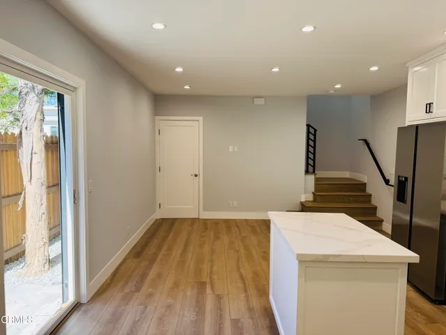 a view of a kitchen with wooden floor and a window