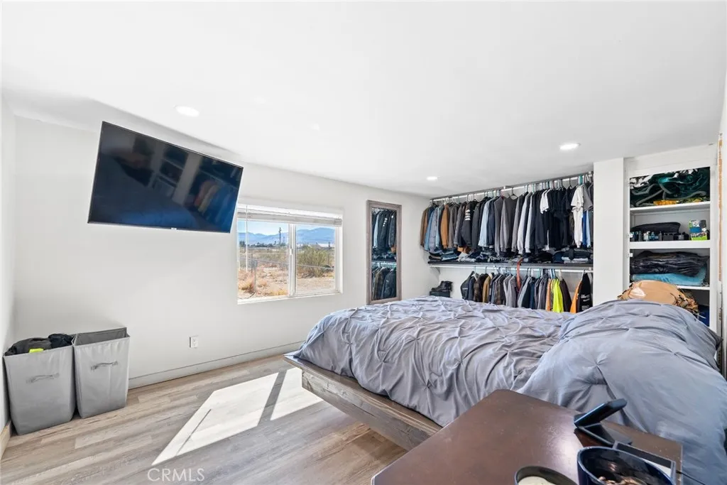 11772 Middleton Road Phelan, CA 92371 - Photo 17 of 40 a bedroom with a bed a bookshelf and a window