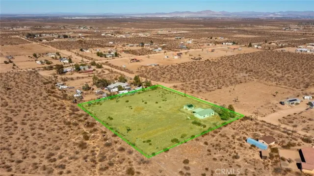 an aerial view of house with yard and mountain in back