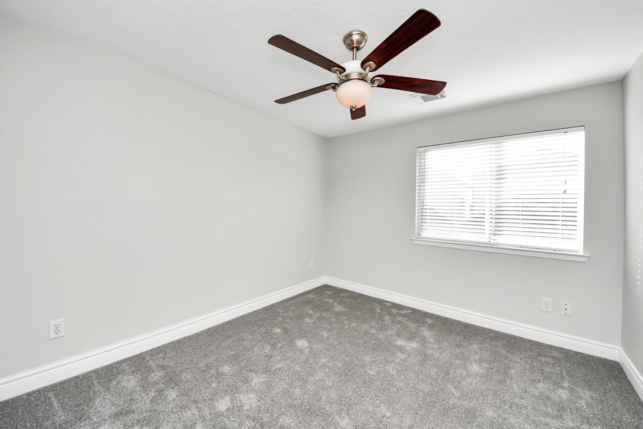 5909 Katy Street Houston, TX 77007 - Photo 26 of 34 Bedroom with neutral newly painted walls, plush new carpet, and a ceiling fan with light. A large window allows natural light to fill the space, making it bright and inviting.
