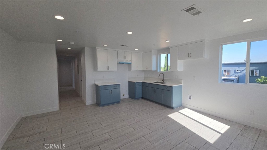 a large kitchen with stainless steel appliances a large counter top a stove and a refrigerator