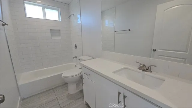 a bathroom with a tub a sink a toilet and mirror