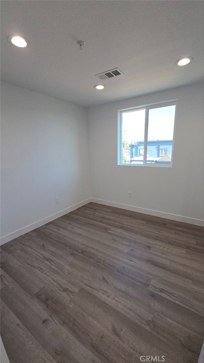 10413 Avalon Boulevard Los Angeles, CA 90003 - Photo 9 of 23 an empty room with wooden floor and windows
