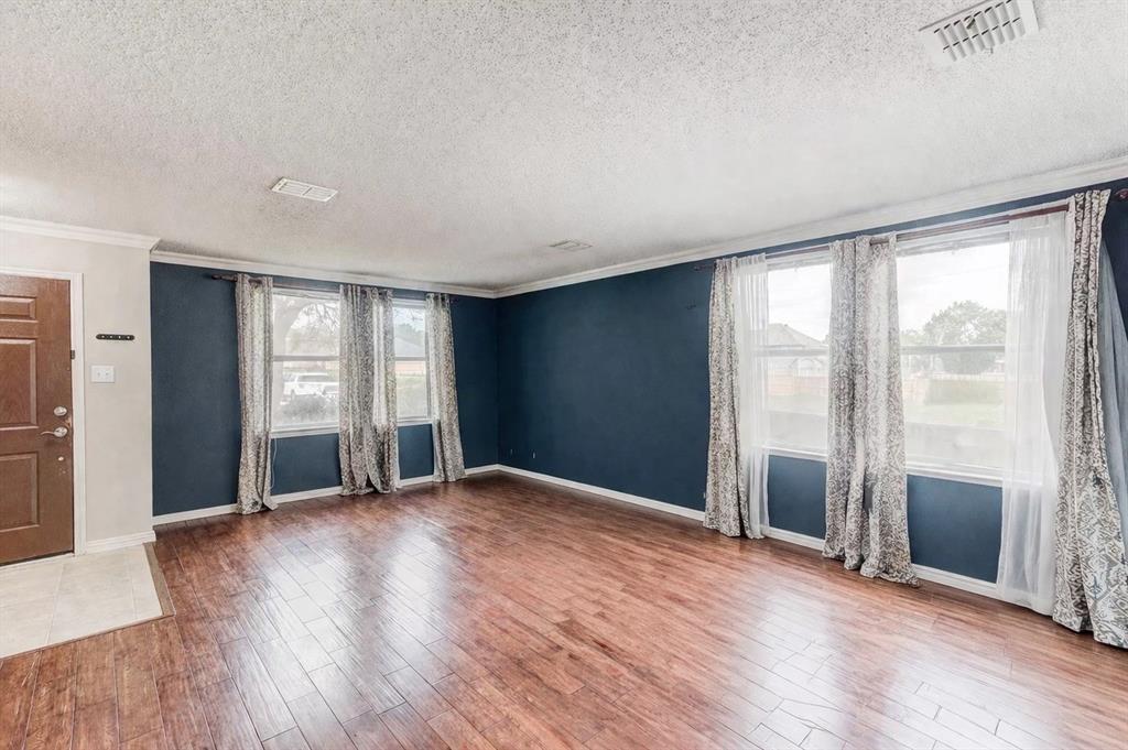 3601 McClintick Road McKinney, TX 75070 - Photo 3 of 24 an empty room with wooden floor and windows