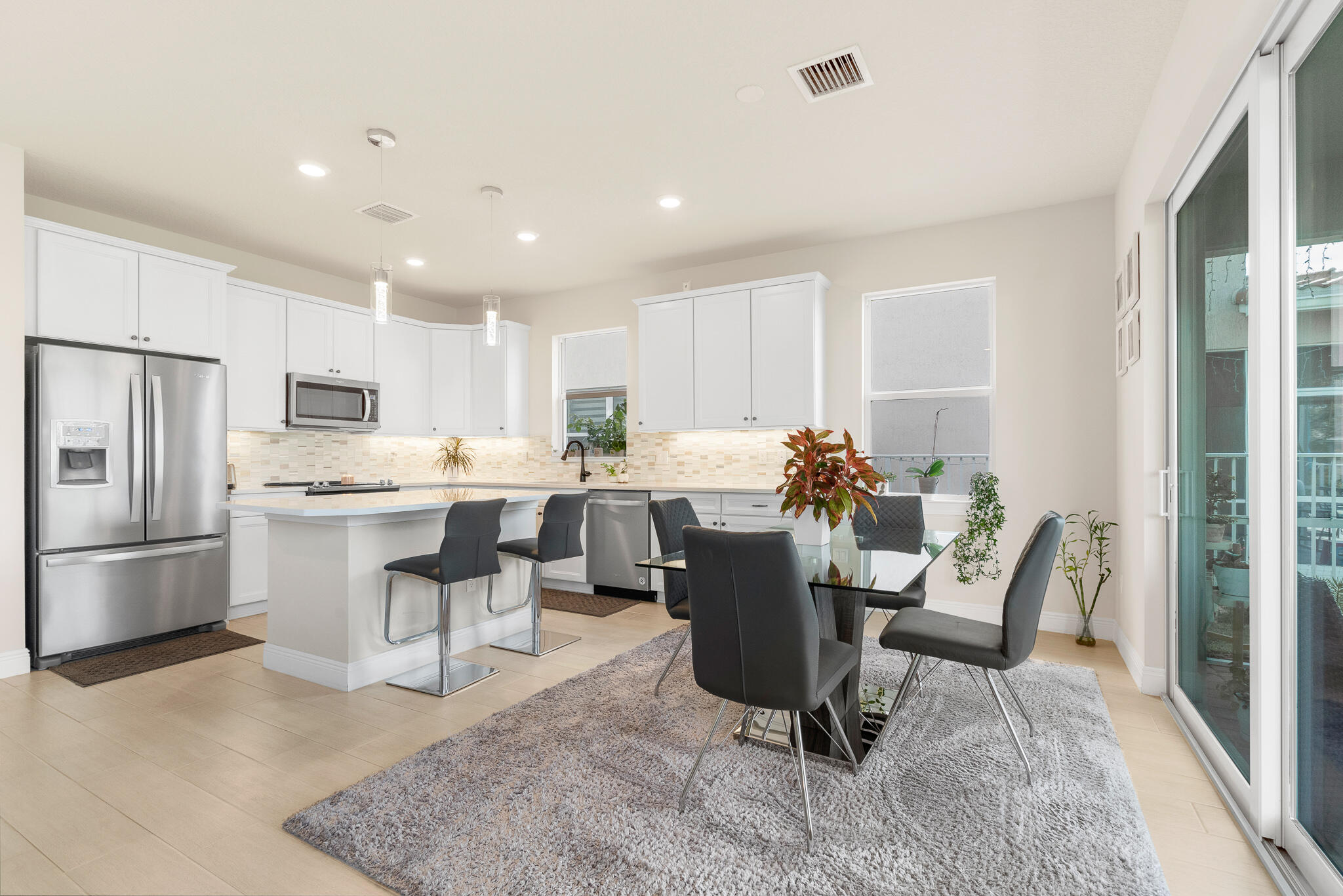 4374 Greenway Drive Hollywood, FL 33021 - Photo 11 of 46 a kitchen with a dining table chairs appliances and cabinets