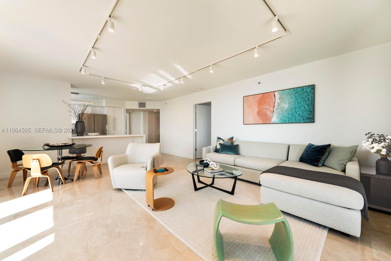 90 Alton Road, Unit 902 Miami Beach, FL 33139 - Photo 24 of 34 a living room with furniture kitchen view and a flat screen tv