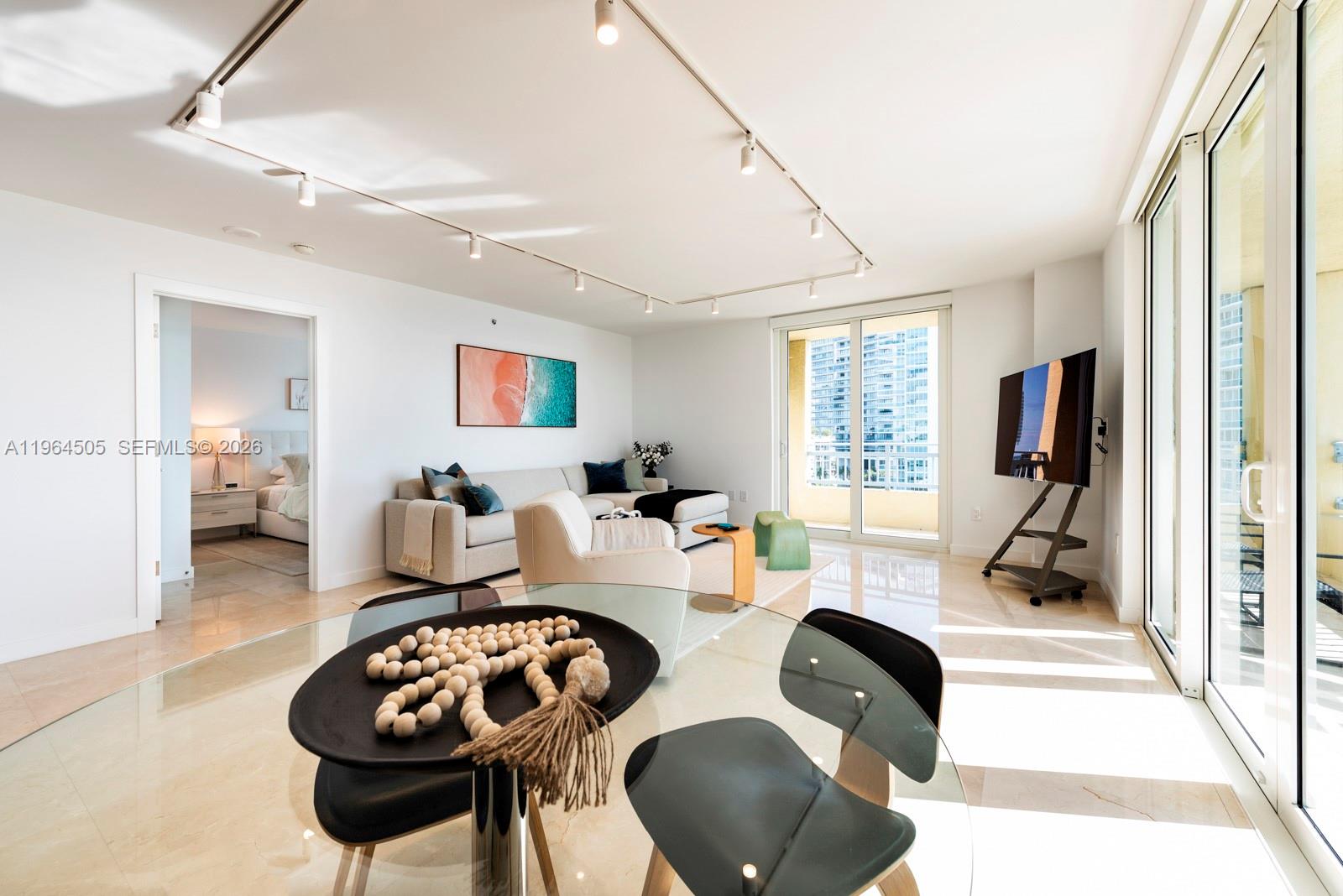 90 Alton Road, Unit 902 Miami Beach, FL 33139 - Photo 25 of 34 a living room with furniture and a flat screen tv