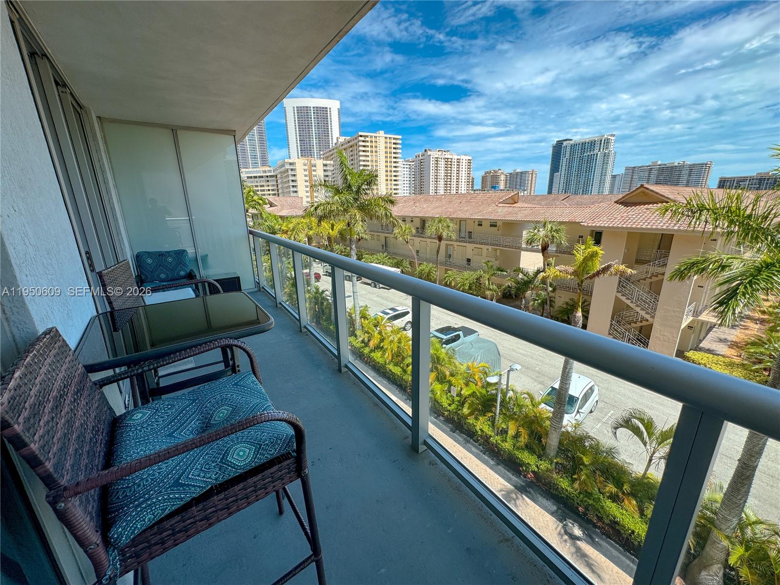 2602 East Hallandale Beach Boulevard, Unit R409 Hallandale Beach, FL 33009 - Photo 19 of 48 a view of a balcony with chairs