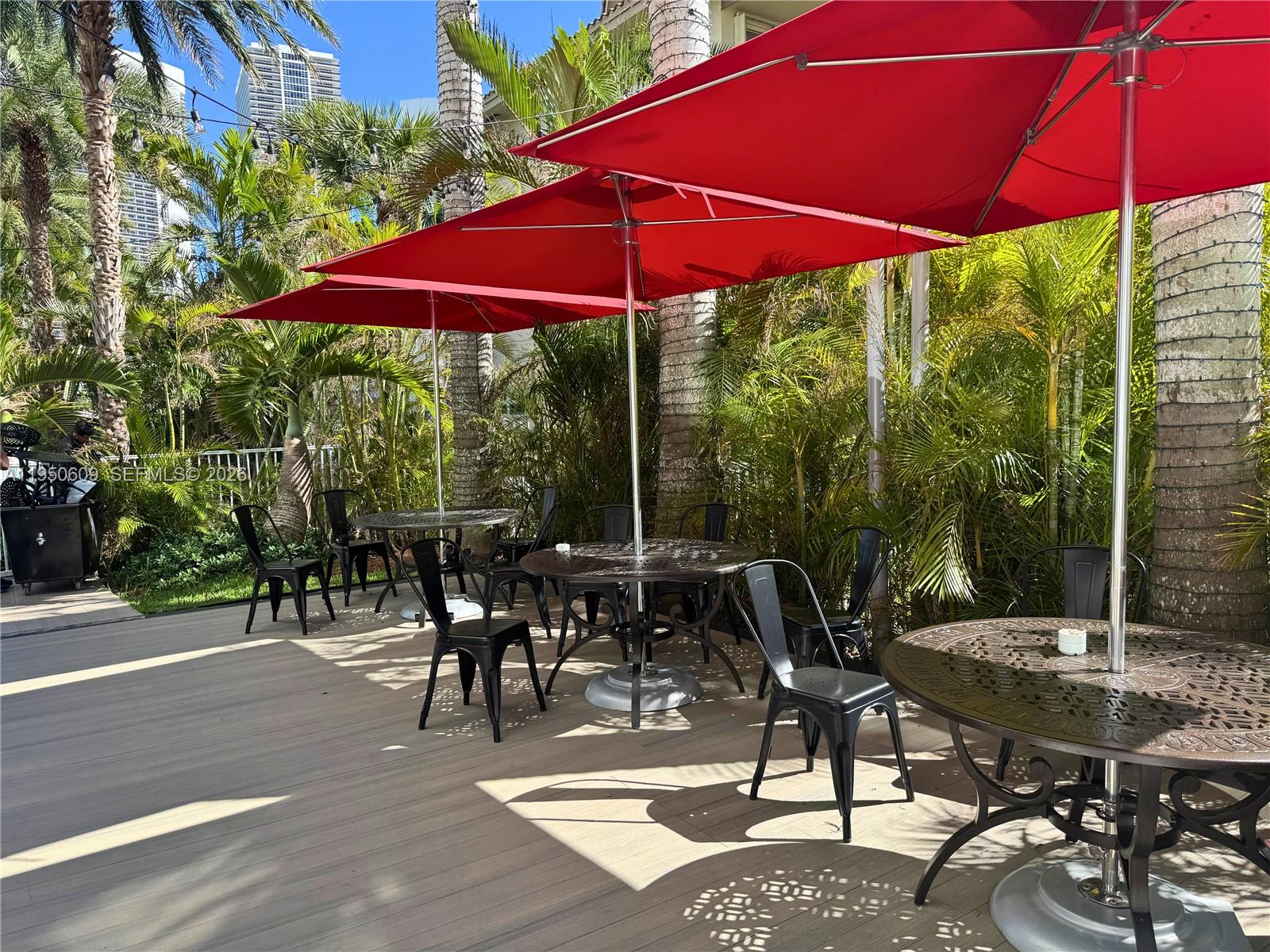 2602 East Hallandale Beach Boulevard, Unit R409 Hallandale Beach, FL 33009 - Photo 40 of 48 a view of a patio with table and chairs under an umbrella