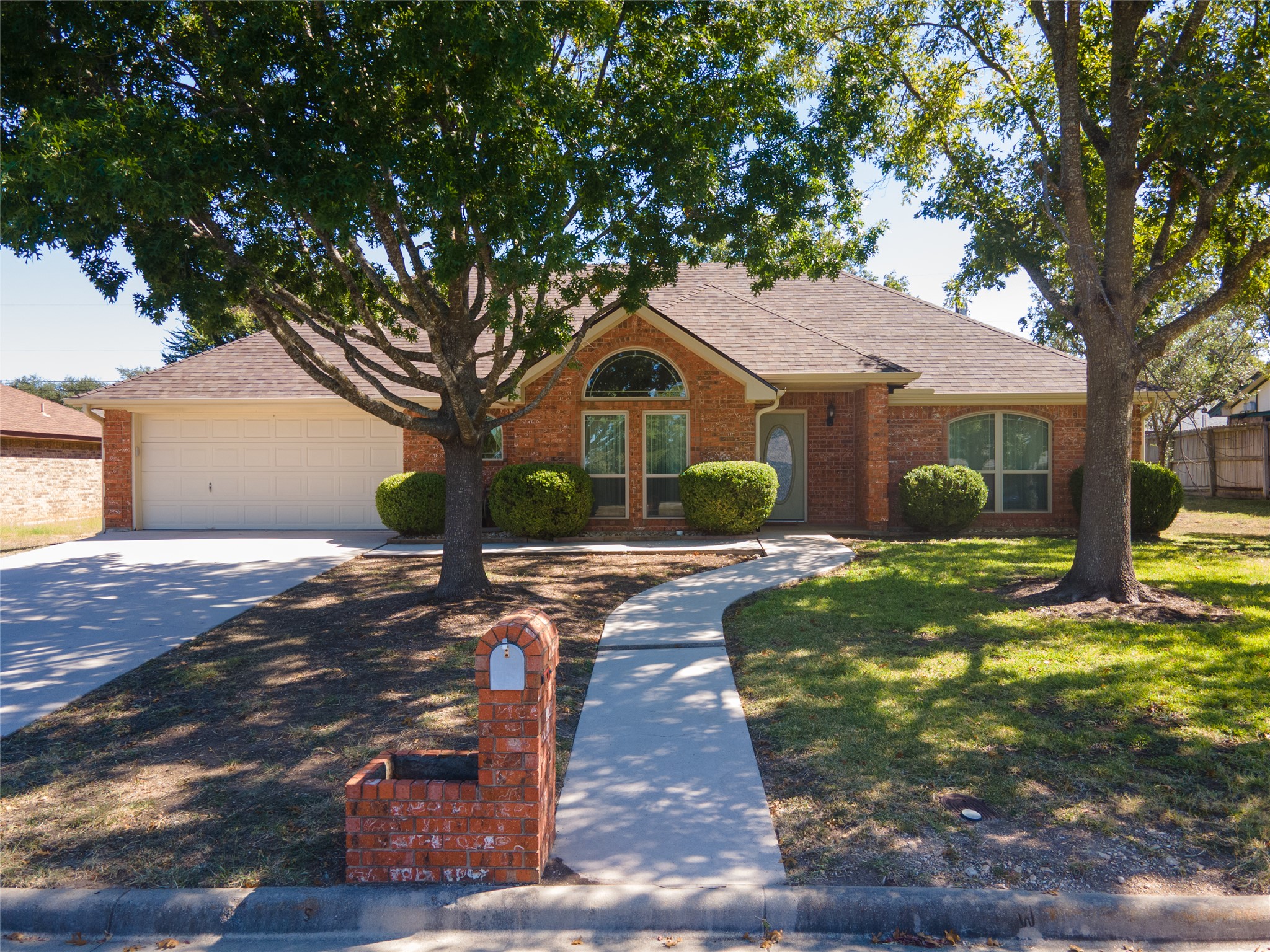 703 Craddock Street Copperas Cove, TX 76522 - Photo 1 of 1 View of front of house with roof with shingles, driveway, brick siding, an attached garage, and a front lawn