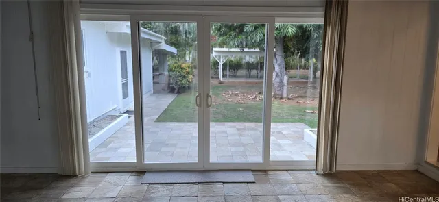 an empty room with windows and chandelier fan