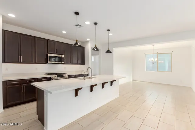 a kitchen with stainless steel appliances granite countertop a sink a stove a refrigerator and cabinets