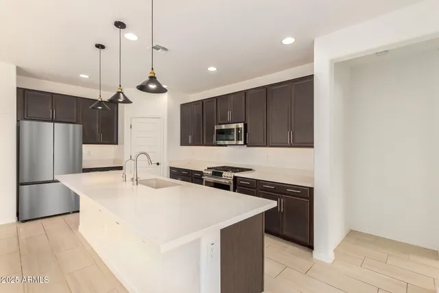 a kitchen with stainless steel appliances granite countertop a sink stove and cabinets