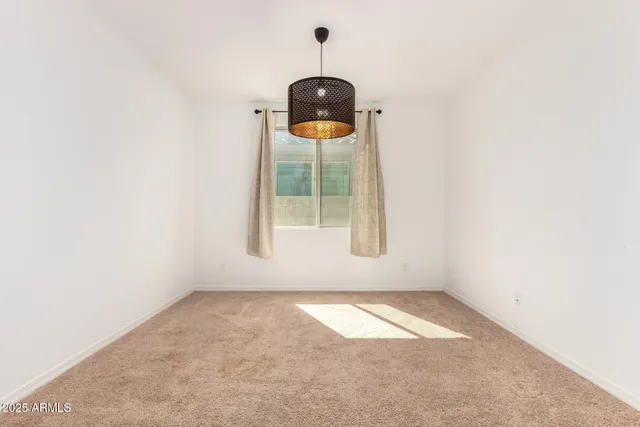 an empty room with a mirror and lamp