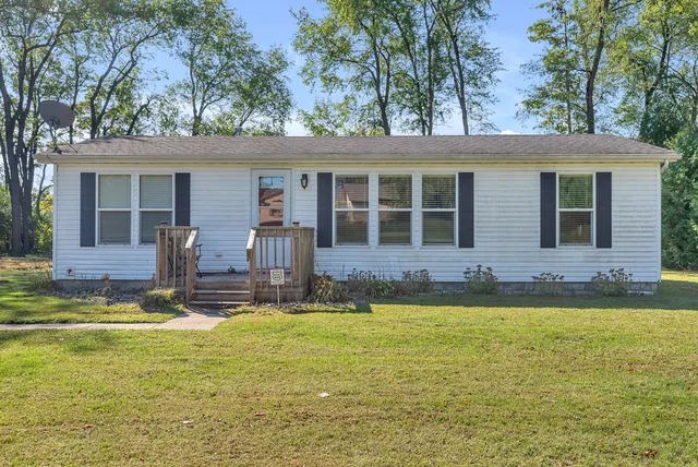 a view of a house with swimming pool next to a yard