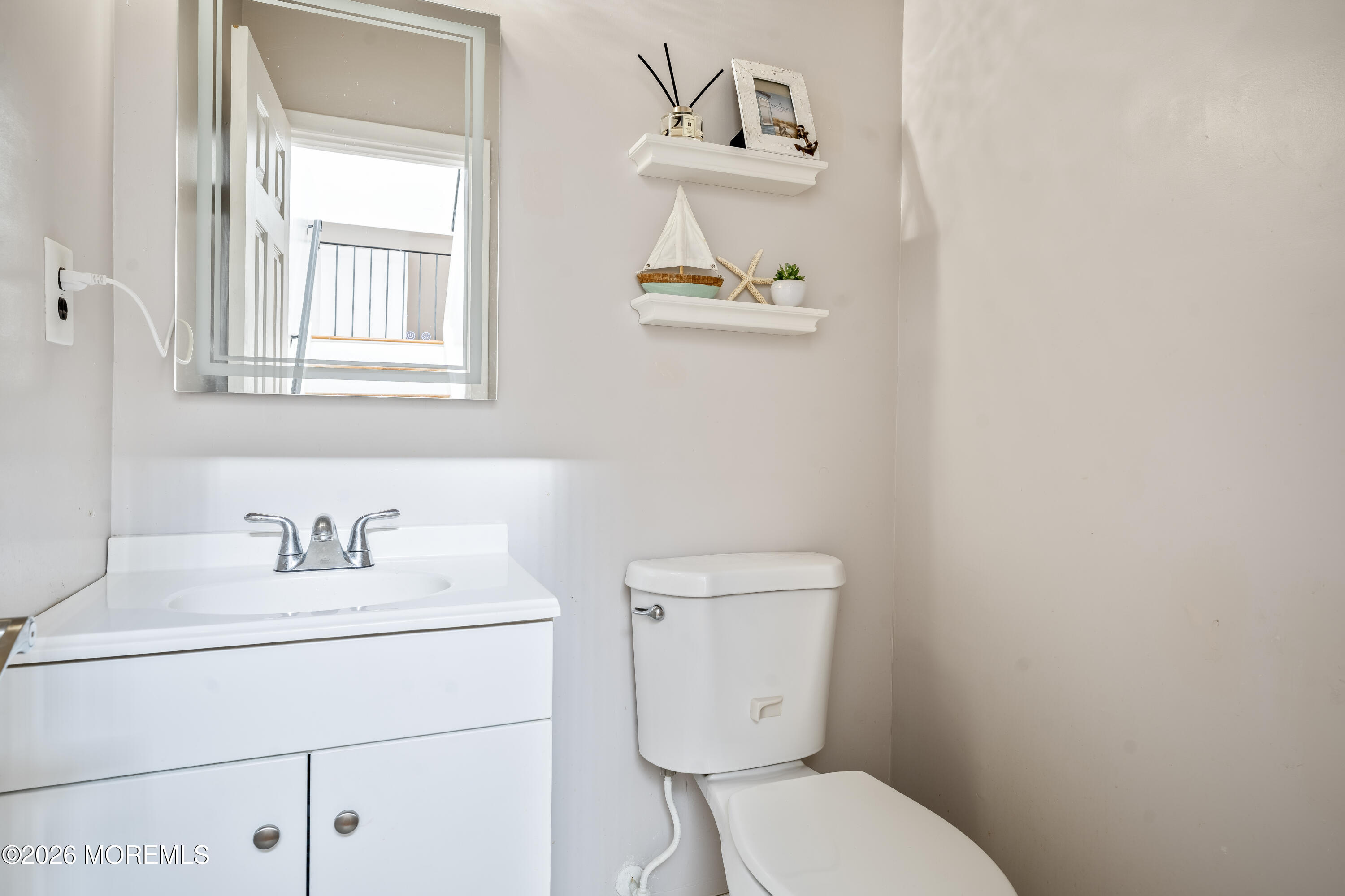 a bathroom with a toilet sink vanity and mirror