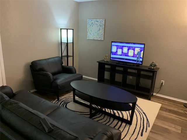 a living room with furniture a rug and a table