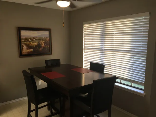a view of a dining room with a table and chairs
