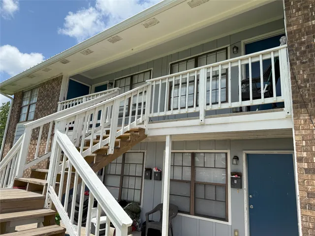 a view of wooden house with large windows and stairs