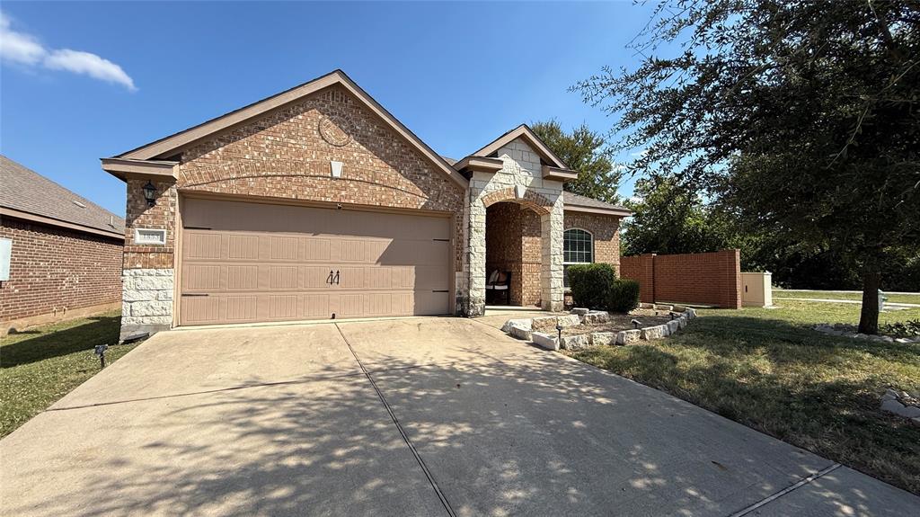 1853 Olive Lane Anna, TX 75409 - Photo 1 of 23 View of front facade with stone siding, a garage, brick siding, and a front lawn
