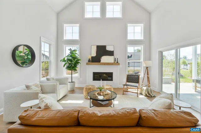 a living room with furniture a fireplace and a large window