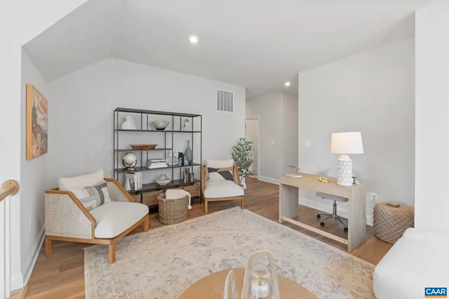 a living room with furniture and a painting on the wall