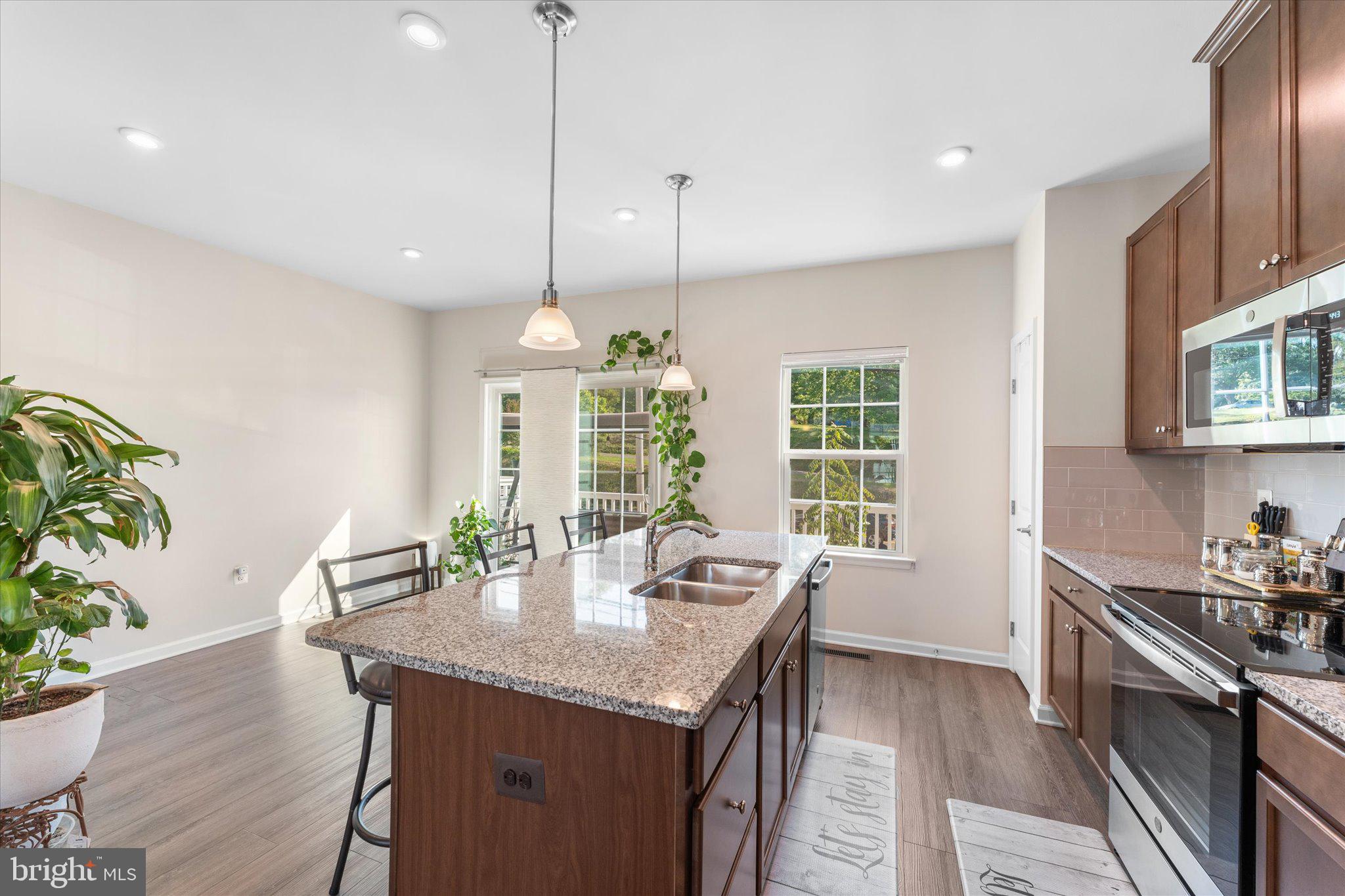 1776 Scenic Loop Culpeper, VA 22701 - Photo 10 of 36 a open kitchen with granite countertop a stove a sink a dining table and chairs with wooden floor