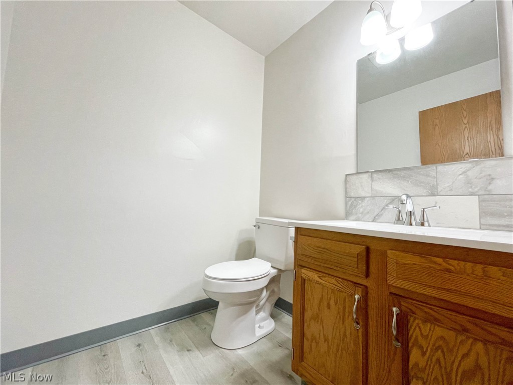 263 Reed Avenue Campbell, OH 44405 - Photo 15 of 30 Bathroom featuring vanity, toilet, decorative backsplash, and hardwood / wood-style floors