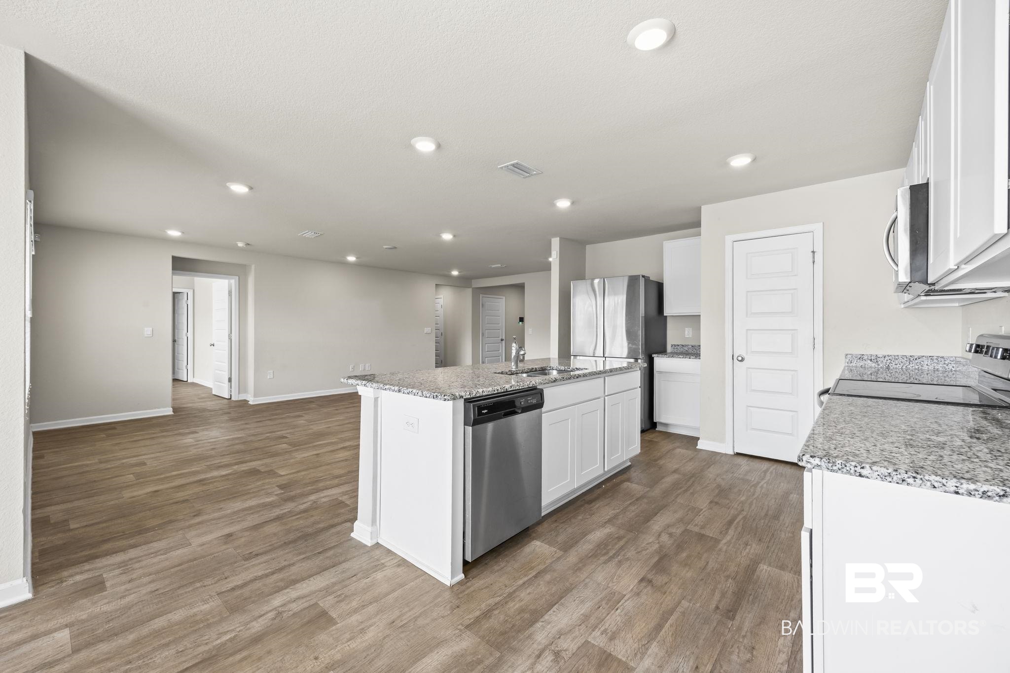 3090 Camino Real Loop Lillian, AL 36549 - Photo 16 of 29 Kitchen with white cabinets, a center island with sink, recessed lighting, appliances with stainless steel finishes, and light wood finished floors