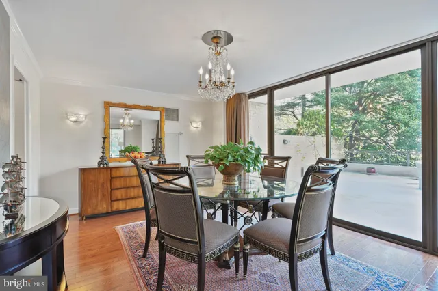 a dining room with furniture a large window and wooden floor