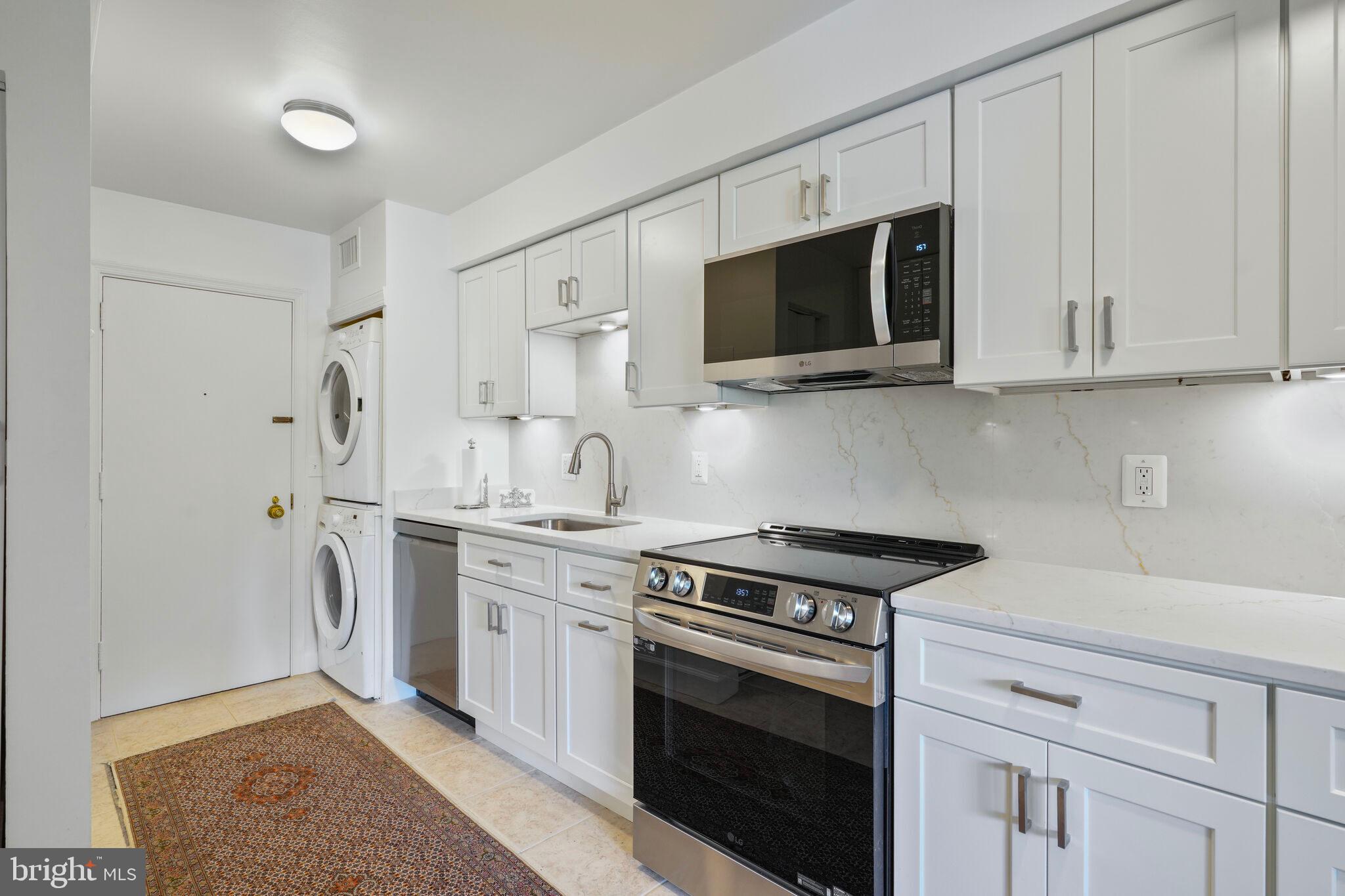 4200 Massachusetts Avenue Northwest, Unit 106 Washington, DC 20016 - Photo 14 of 48 a kitchen with stainless steel appliances granite countertop white cabinets a stove a microwave and a sink