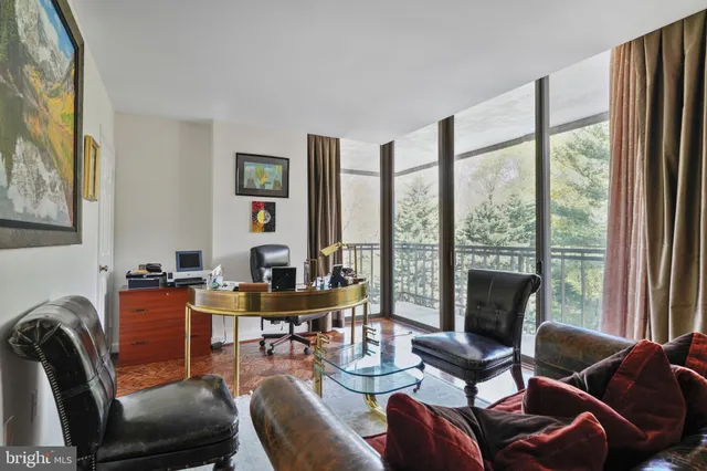 a work room with furniture and floor to ceiling windows