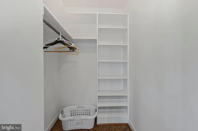 a view of walk in closet with empty racks