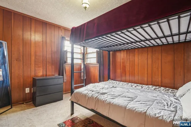 a bed sitting in a spacious bedroom next to a window