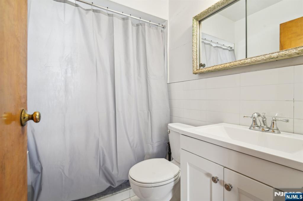 163 Kent Street Hackensack, NJ 07601 - Photo 15 of 19 a bathroom with a sink a toilet and shower