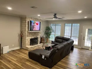a living room with furniture a fireplace and a floor to ceiling window