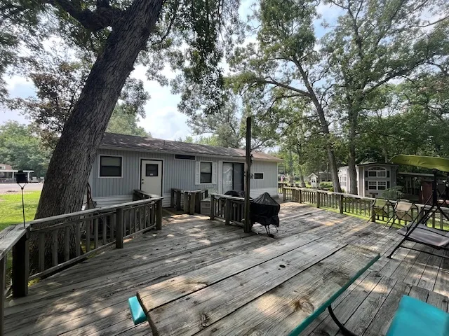 a view of backyard with deck and outdoor seating