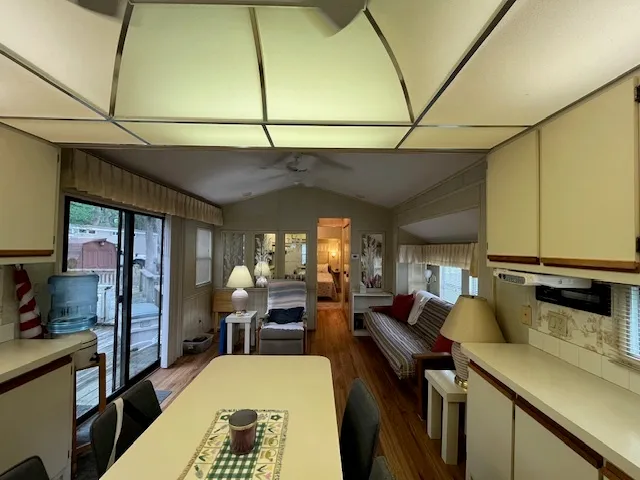 a view of a kitchen with kitchen island a large window cabinets a sink and stainless steel appliances