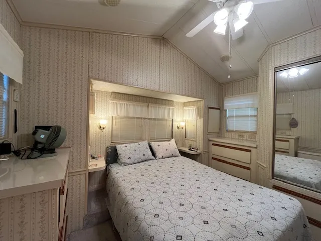 a bedroom with a bed and a large mirror on the dresser