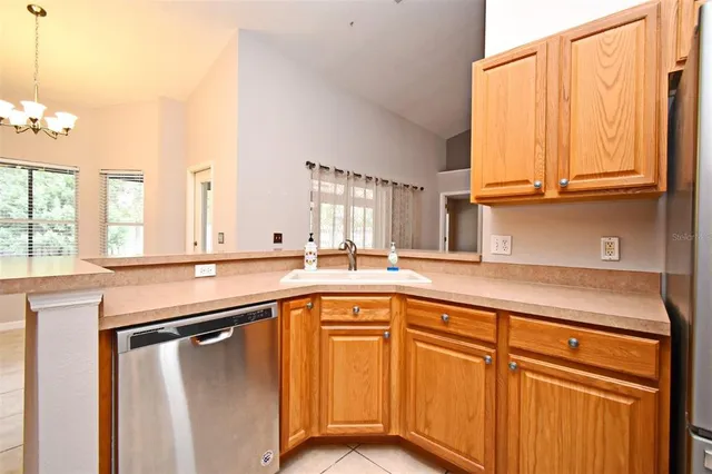a kitchen with stainless steel appliances granite countertop a sink and dishwasher with wooden cabinets