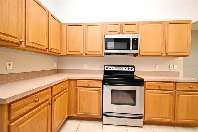 a kitchen with granite countertop a stove top oven microwave and cabinets