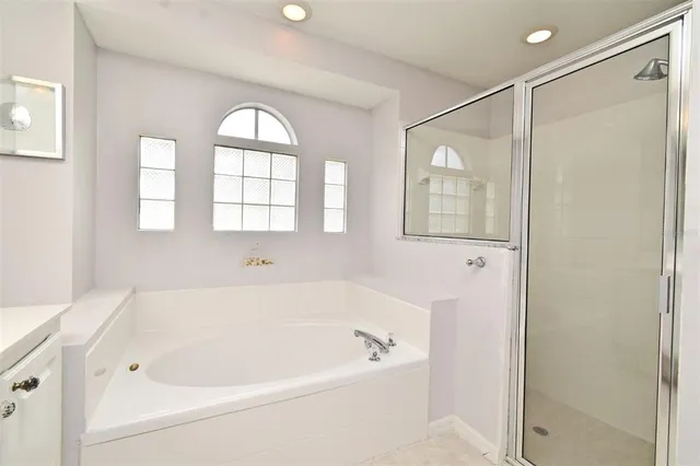 a white bath tub sitting next to a shower
