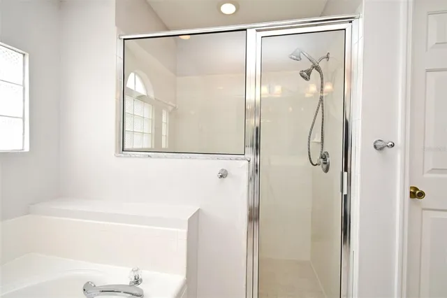 a bathroom with a glass shower door and a shower